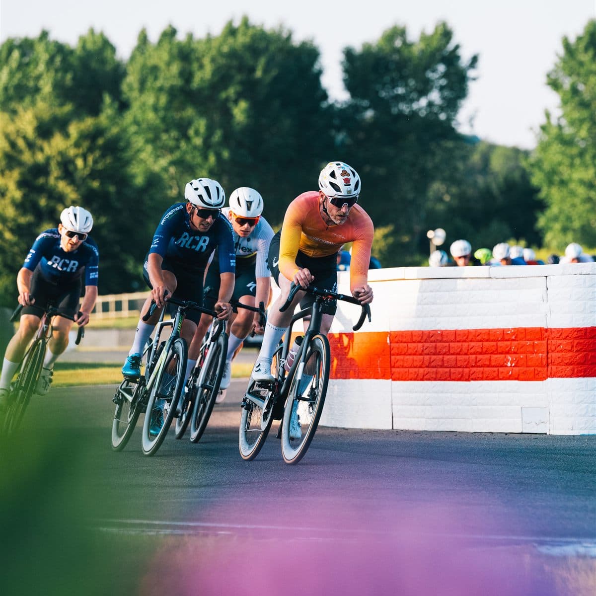 A PowerWatts member leading a group of riders through a corner at a criterium race
